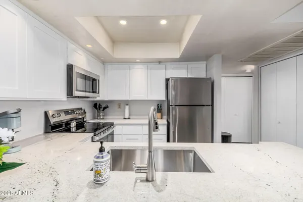 a kitchen with stainless steel appliances granite countertop a refrigerator and a sink