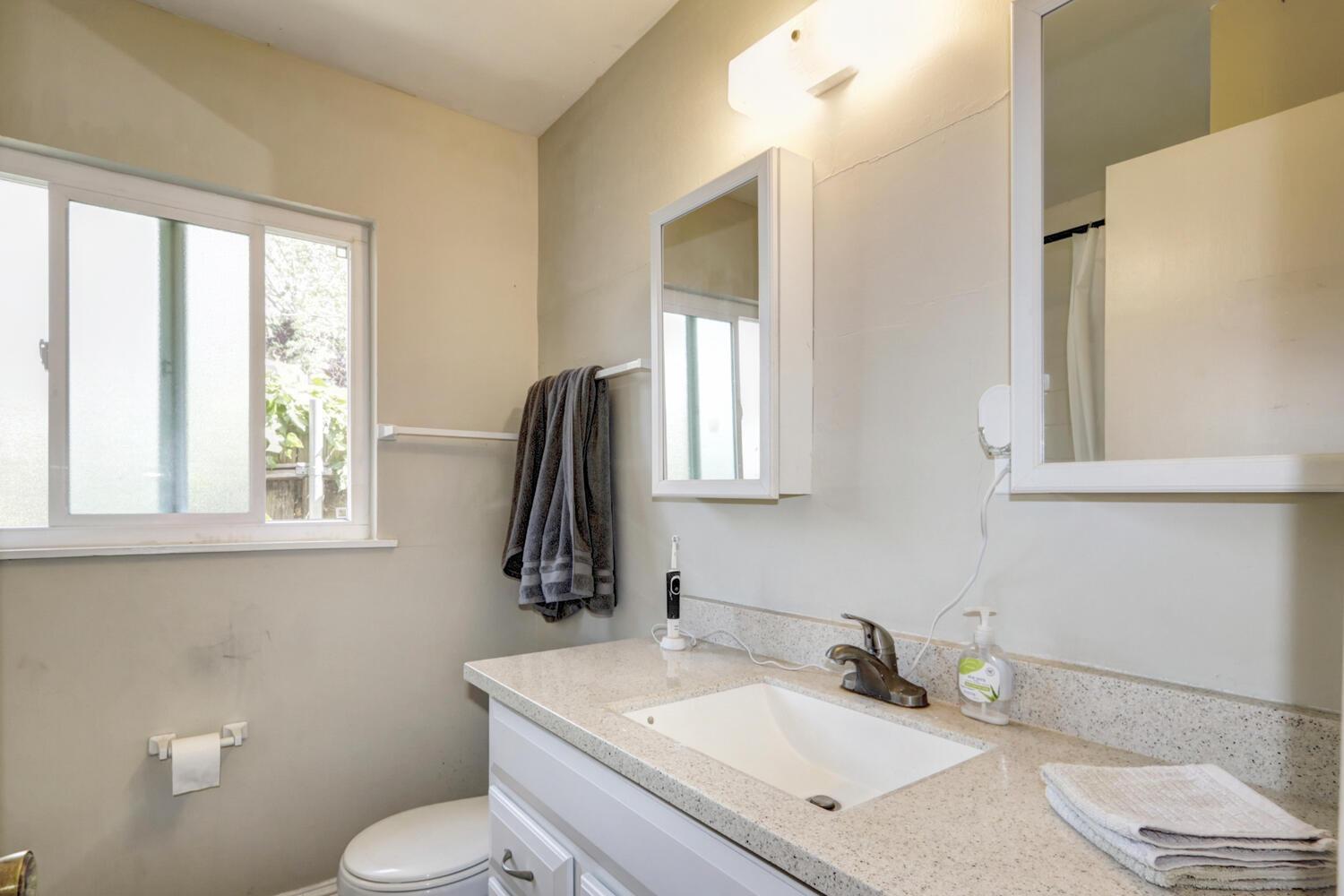 520-522 Oeste Drive Davis, CA 95616 - Photo 19 of 54 a bathroom with a granite countertop sink toilet and a mirror