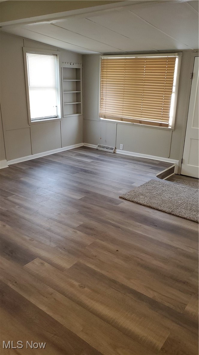 17610 Brazil Road Cleveland, OH 44119 - Photo 23 of 50 Empty room featuring dark wood-type flooring and built in shelves