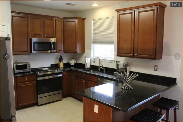 a kitchen with kitchen island granite countertop a sink stainless steel appliances and cabinets