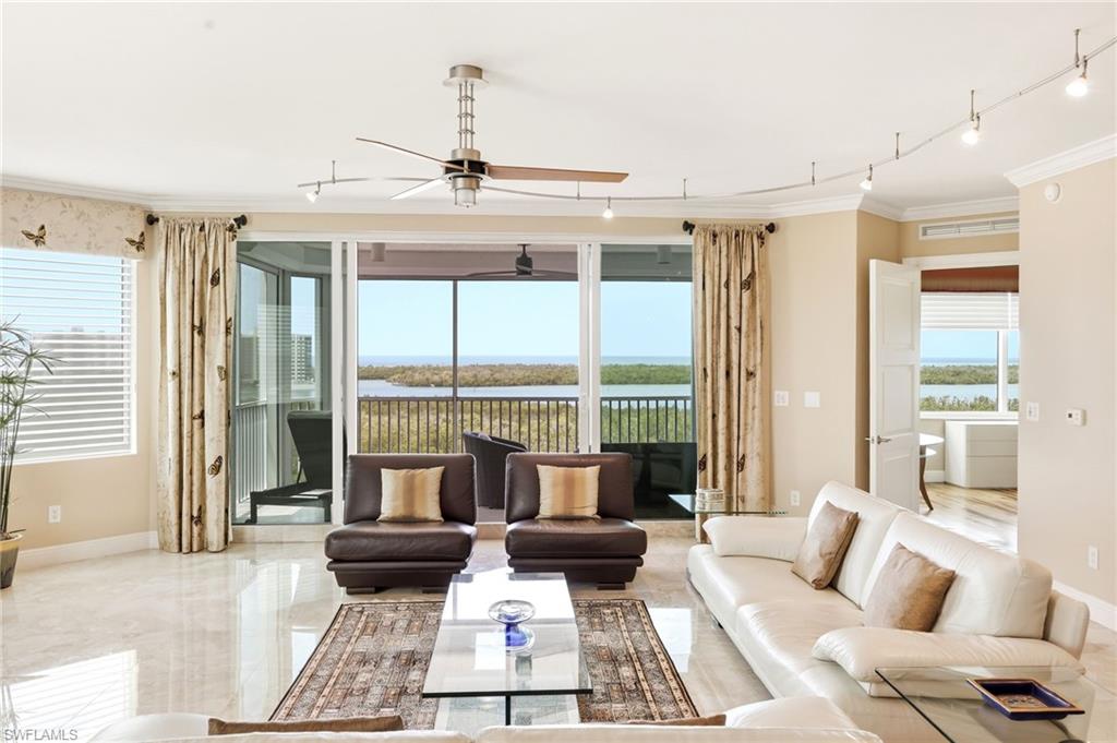 265 Indies Way, Unit 701 Naples, FL 34110 - Photo 1 of 50 a living room with furniture and floor to ceiling windows