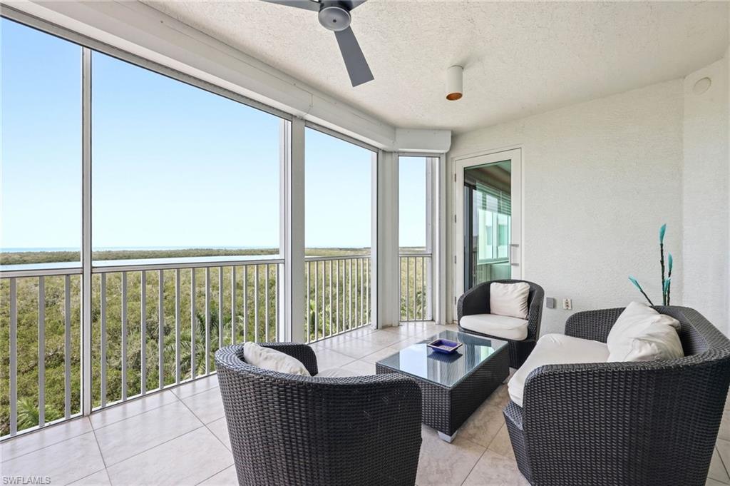 265 Indies Way, Unit 701 Naples, FL 34110 - Photo 12 of 50 a living room with furniture and a floor to ceiling window