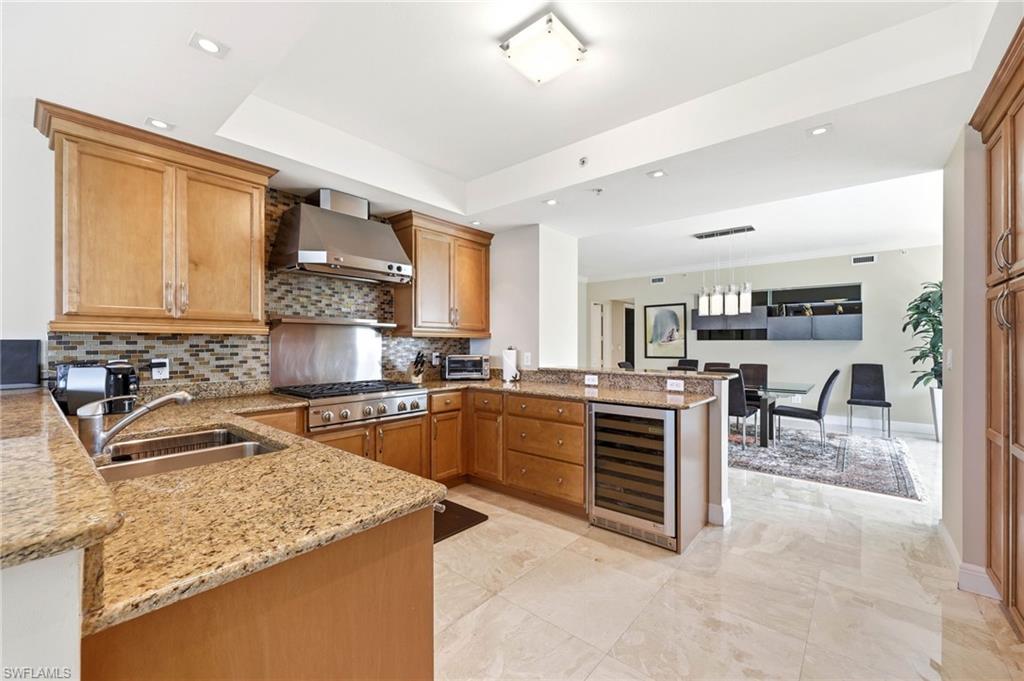265 Indies Way, Unit 701 Naples, FL 34110 - Photo 14 of 50 a kitchen with granite countertop a sink stove and cabinets