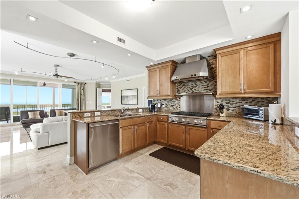265 Indies Way, Unit 701 Naples, FL 34110 - Photo 15 of 50 a kitchen with stainless steel appliances granite countertop a stove sink and cabinets