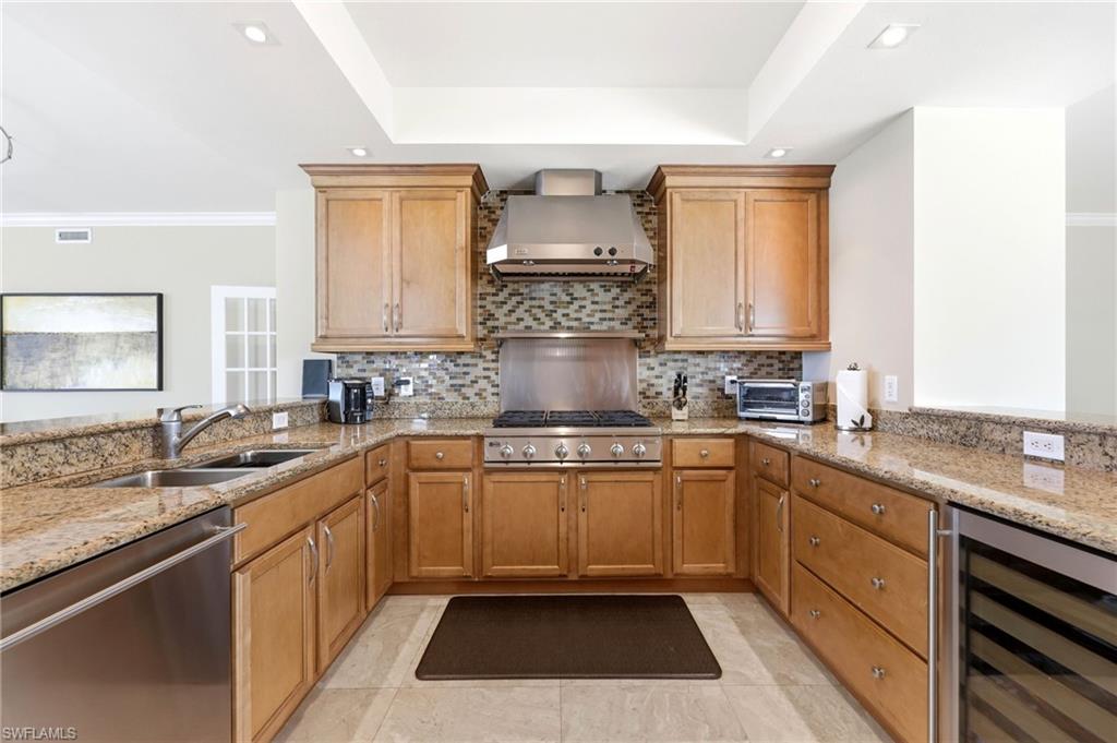 265 Indies Way, Unit 701 Naples, FL 34110 - Photo 16 of 50 a kitchen with a sink stove and cabinets
