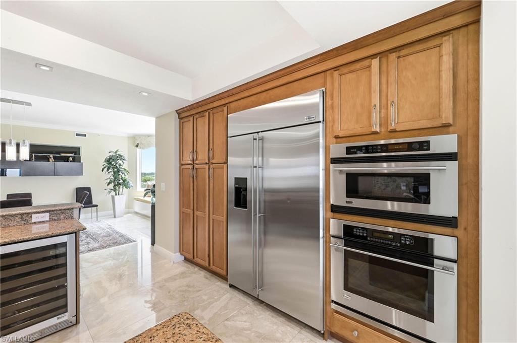 265 Indies Way, Unit 701 Naples, FL 34110 - Photo 18 of 50 a kitchen with granite countertop a refrigerator and stove