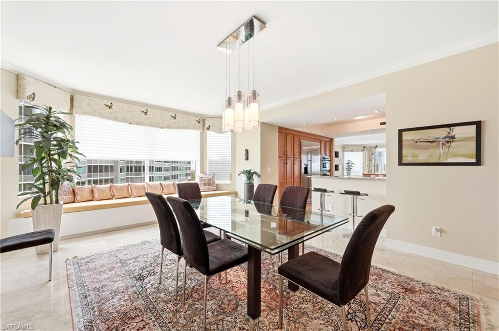 265 Indies Way, Unit 701 Naples, FL 34110 - Photo 20 of 50 a dining room with furniture a rug and a chandelier