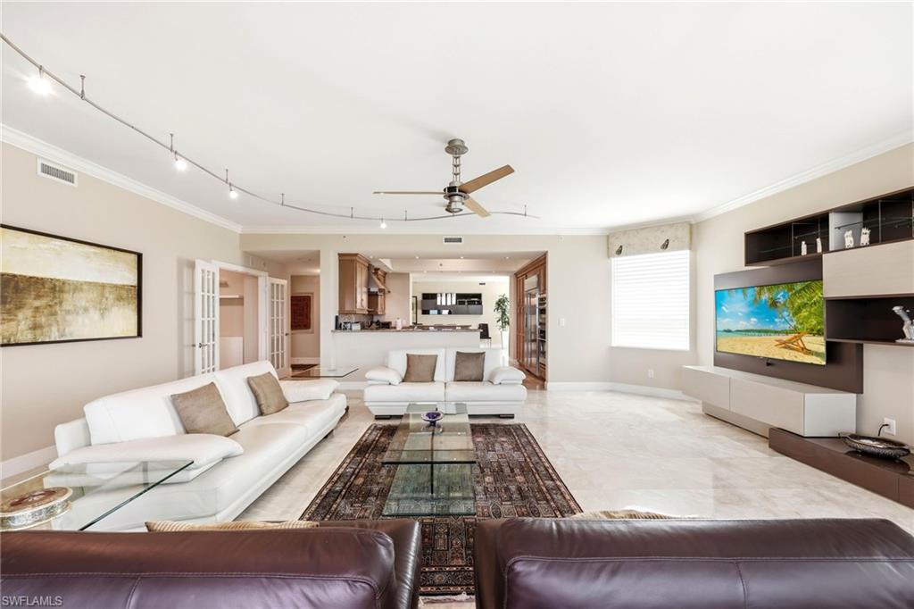265 Indies Way, Unit 701 Naples, FL 34110 - Photo 2 of 50 a living room with furniture and a flat screen tv