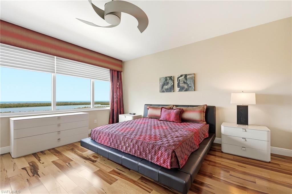265 Indies Way, Unit 701 Naples, FL 34110 - Photo 23 of 50 a bedroom with a large bed and a large window