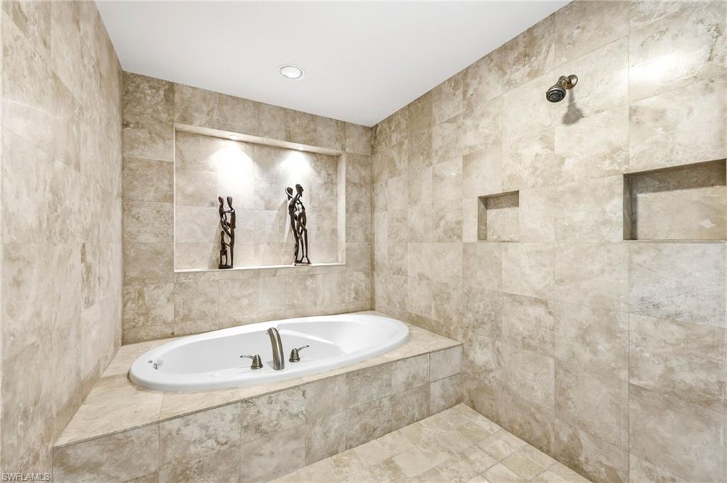 265 Indies Way, Unit 701 Naples, FL 34110 - Photo 27 of 50 a bathroom with a bathtub and shower