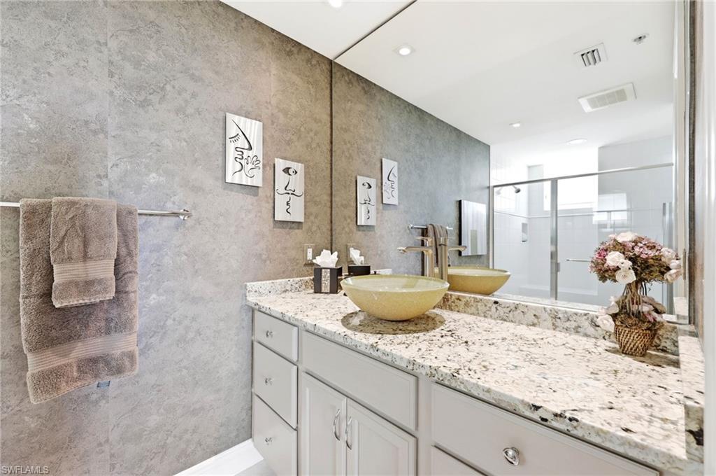 265 Indies Way, Unit 701 Naples, FL 34110 - Photo 31 of 50 a bathroom with a granite countertop sink a mirror and shower