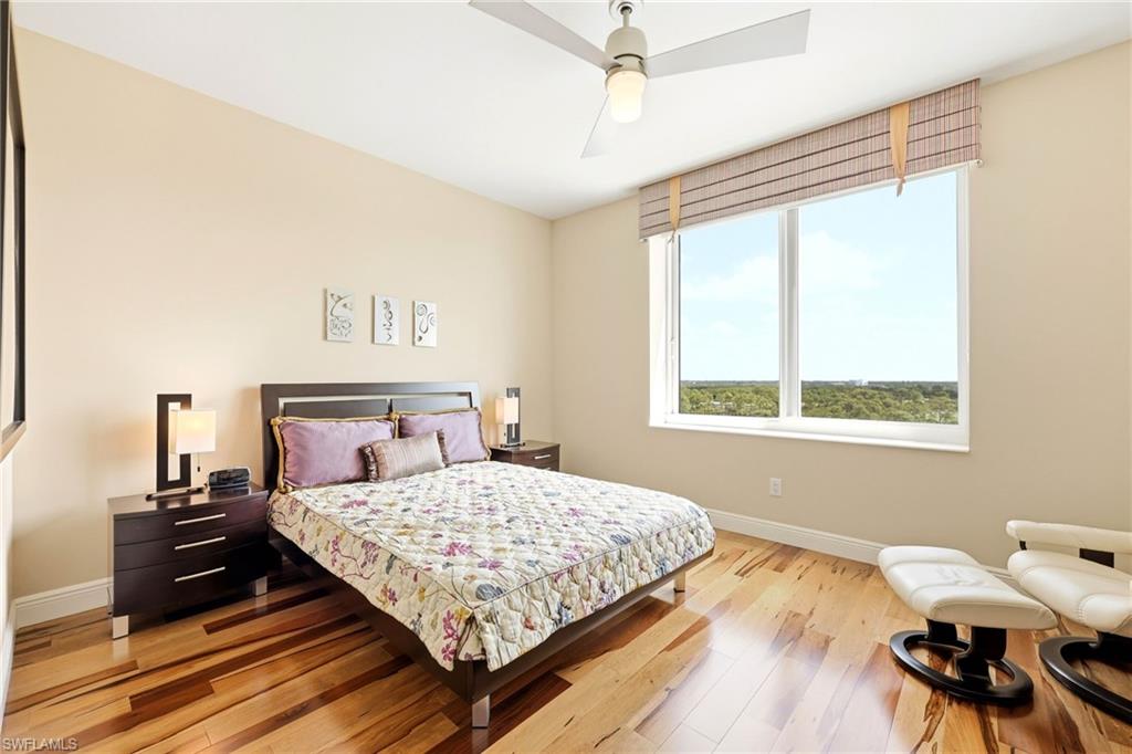 265 Indies Way, Unit 701 Naples, FL 34110 - Photo 33 of 50 a bedroom with a bed and wooden floor