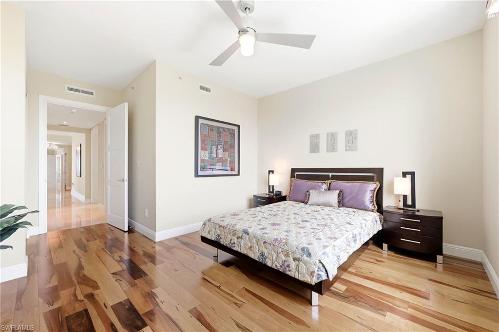 265 Indies Way, Unit 701 Naples, FL 34110 - Photo 34 of 50 a bedroom with a bed and a chandelier