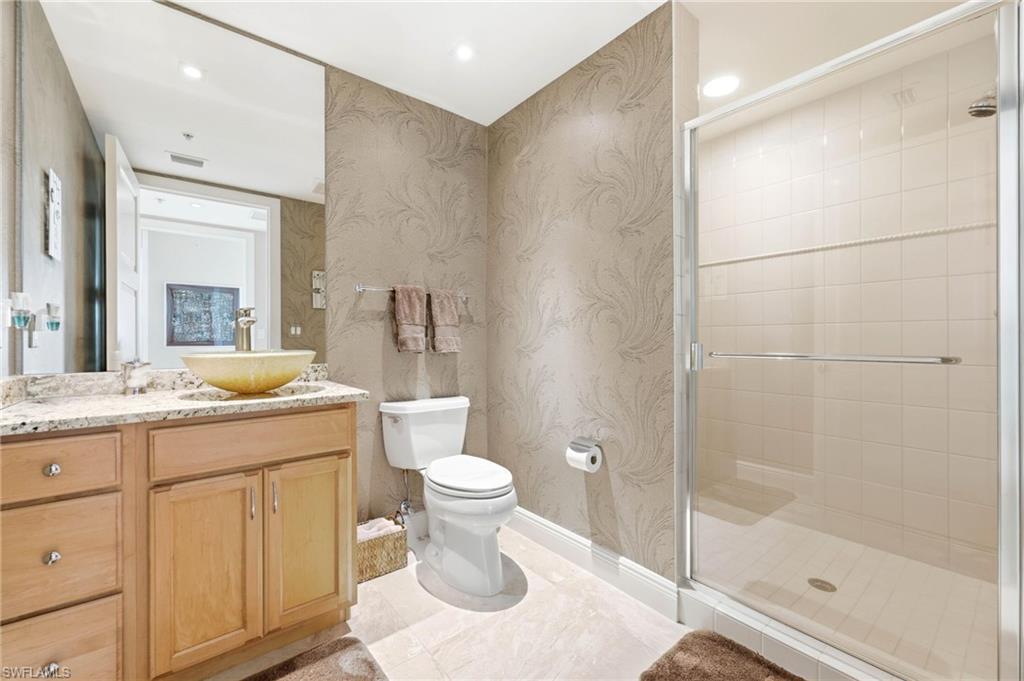 265 Indies Way, Unit 701 Naples, FL 34110 - Photo 36 of 50 a bathroom with a granite countertop sink toilet and shower