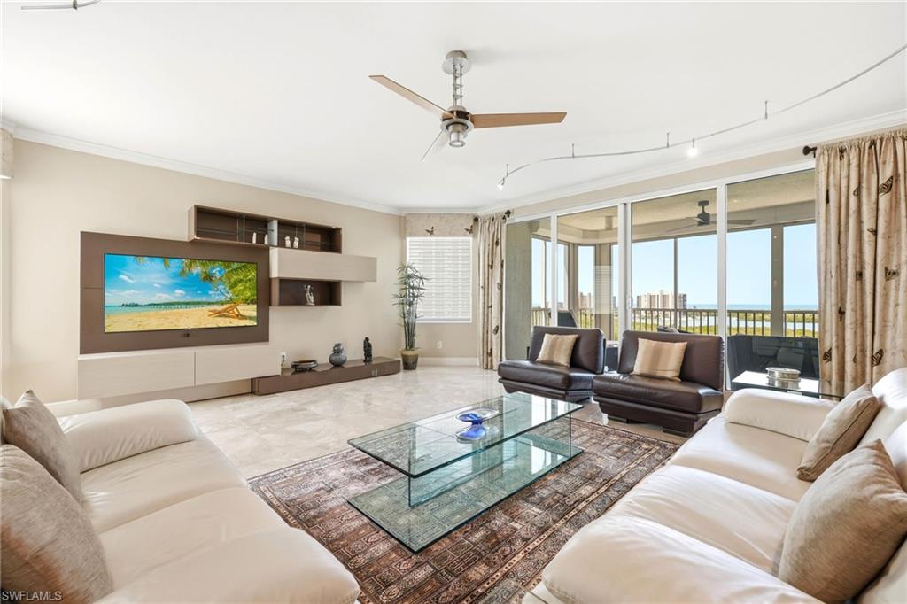265 Indies Way, Unit 701 Naples, FL 34110 - Photo 7 of 50 a living room with furniture ceiling fan and a large window