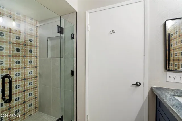 a bathroom with a granite countertop shower and a sink