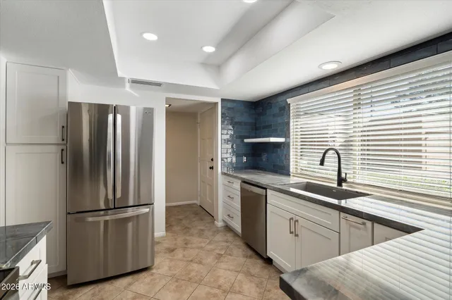 a kitchen with stainless steel appliances granite countertop a refrigerator and a sink