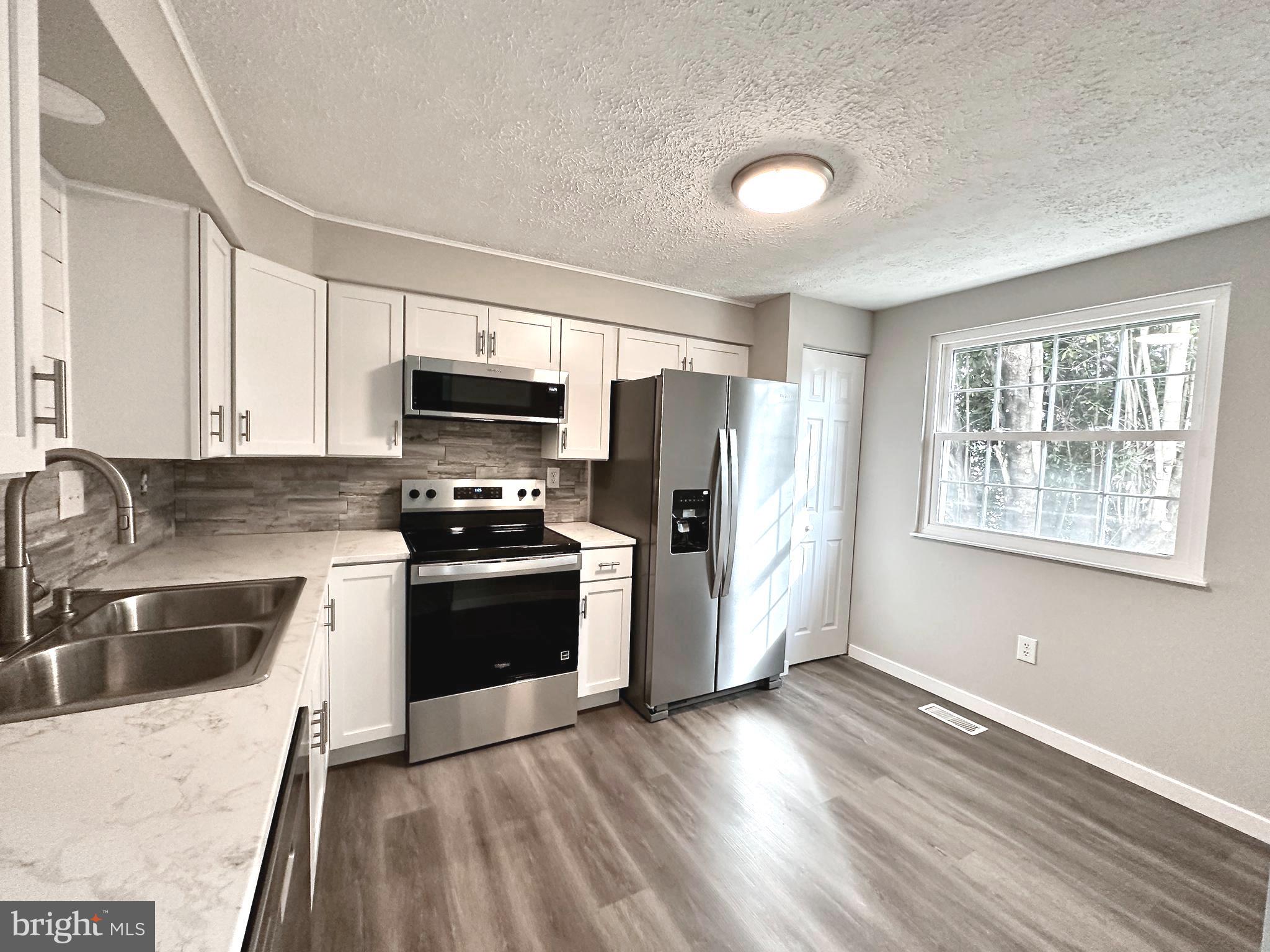 1776 Springfield Lane Frederick, MD 21702 - Photo 16 of 56 a kitchen with granite countertop a refrigerator stove and sink