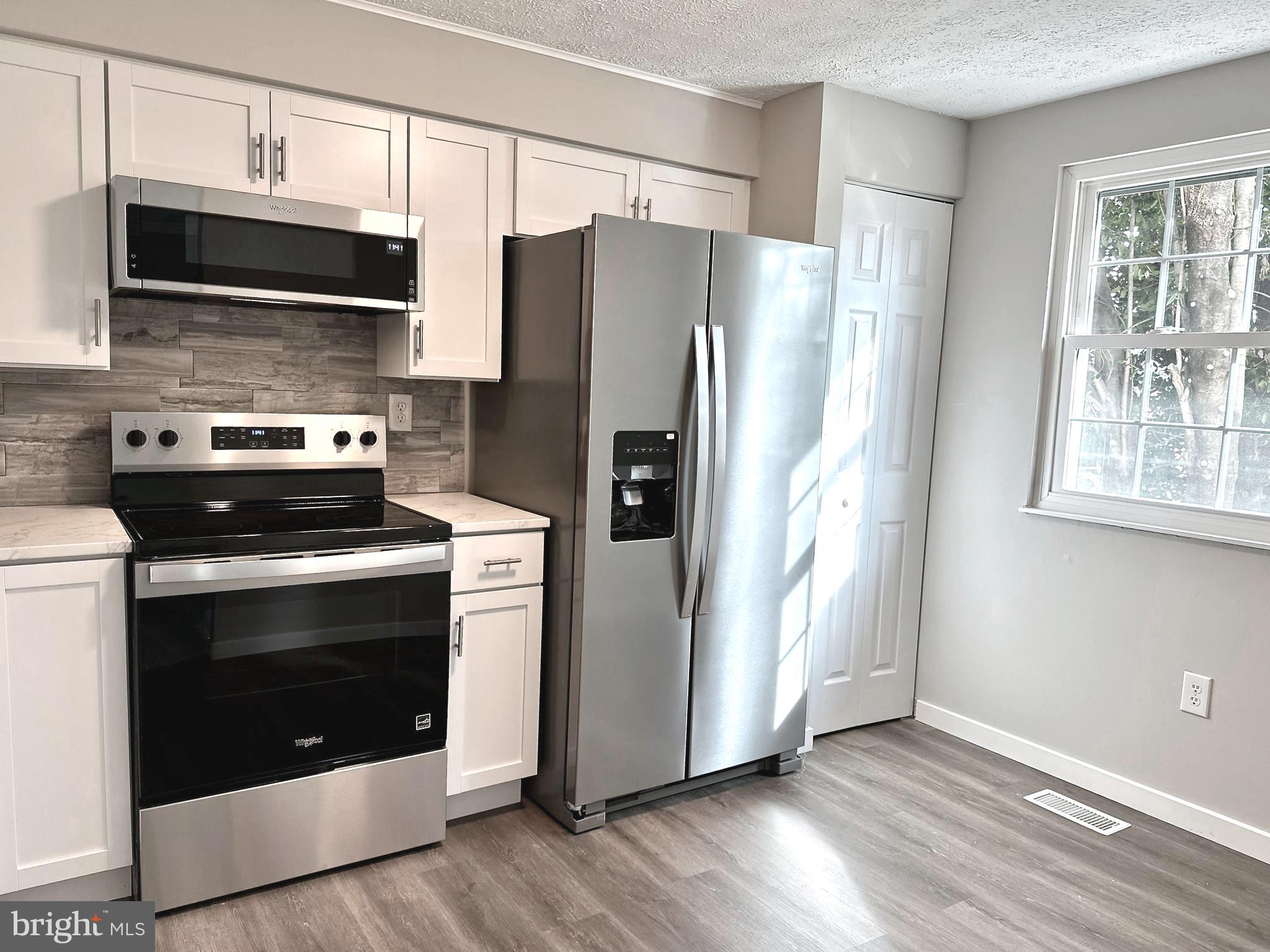 1776 Springfield Lane Frederick, MD 21702 - Photo 18 of 56 a kitchen with stainless steel appliances a stove a microwave and a refrigerator