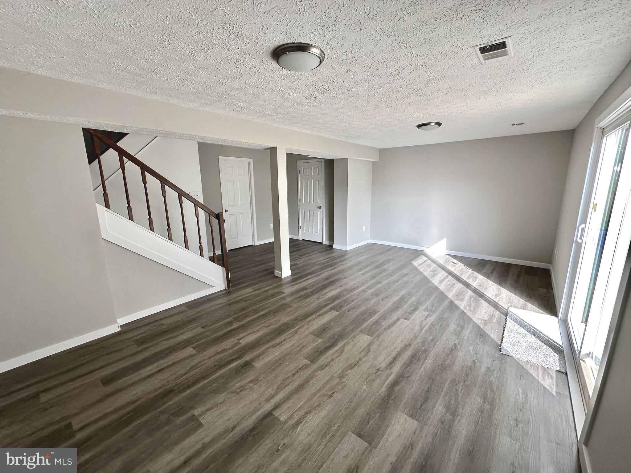 1776 Springfield Lane Frederick, MD 21702 - Photo 47 of 56 a view of an empty room with wooden floor and stairs