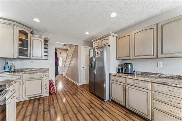 a kitchen with stainless steel appliances granite countertop a refrigerator stove and sink