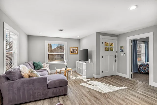 a living room with furniture flowerpot and wooden floor