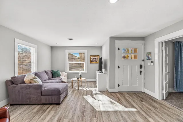 a living room with furniture flowerpot and wooden floor