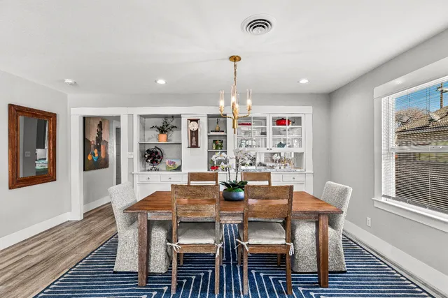 a dining room with furniture window and wooden floor