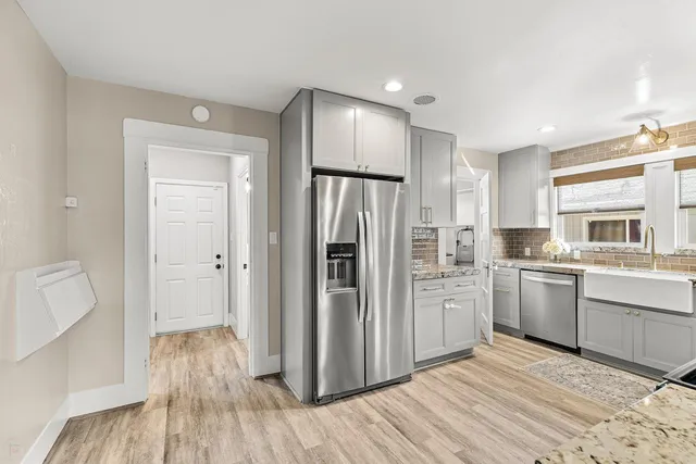 a kitchen with stainless steel appliances granite countertop a stove a sink and a microwave