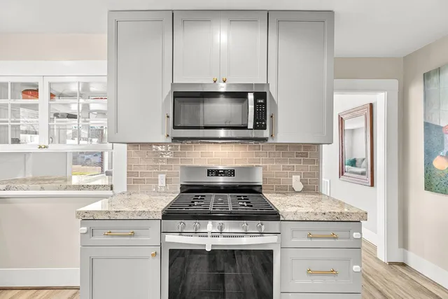 a kitchen with stainless steel appliances granite countertop a sink and a window