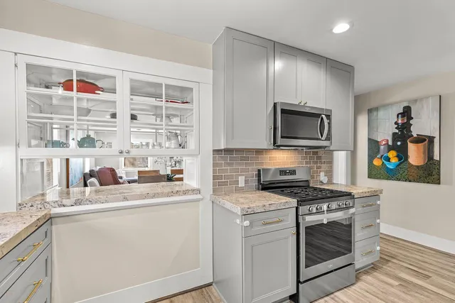 a kitchen with stainless steel appliances granite countertop a sink and a stove