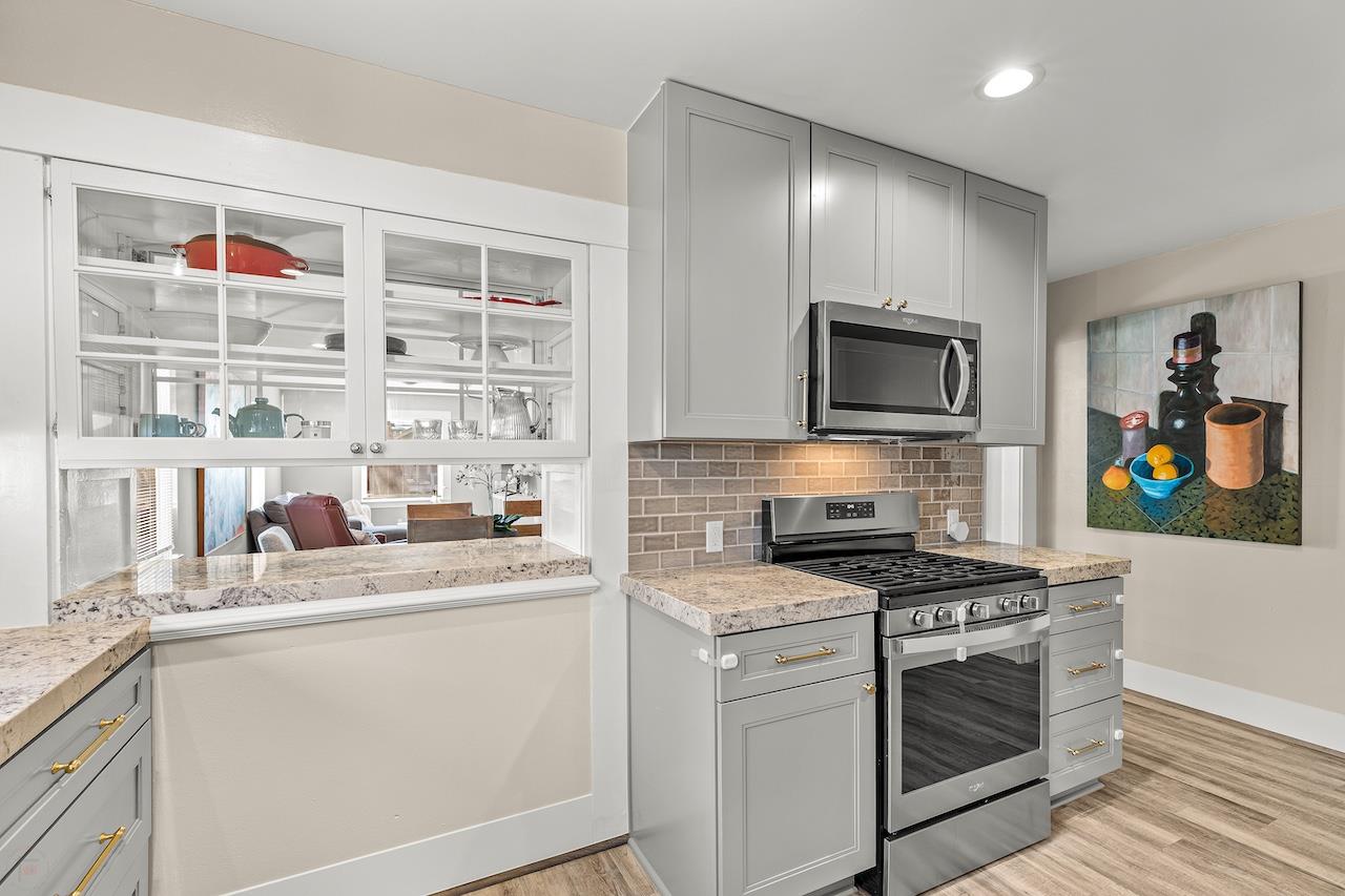 319 West 12th Street Tracy, CA 95376 - Photo 21 of 51 a kitchen with stainless steel appliances granite countertop a stove a sink and a microwave