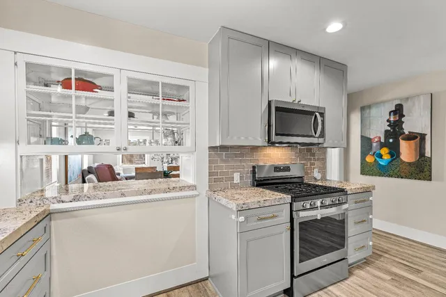 a kitchen with stainless steel appliances granite countertop a sink and cabinets