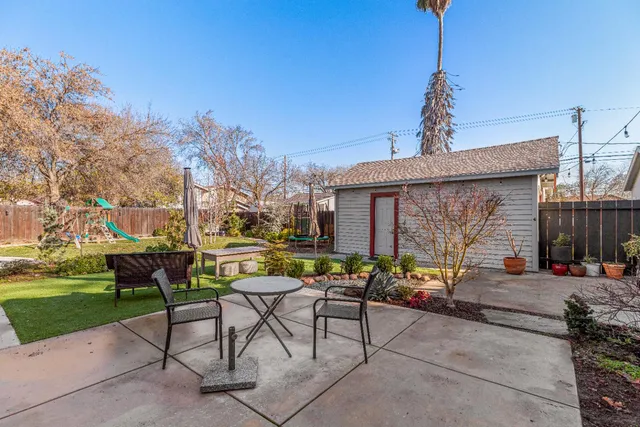 a backyard of a house with table and chairs
