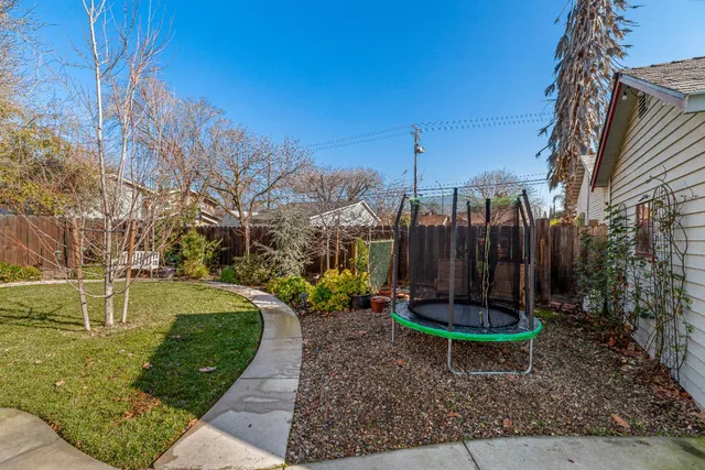 a view of backyard with swimming pool and seating space