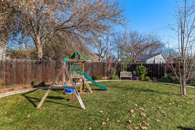 a view of a park with slide and a bench