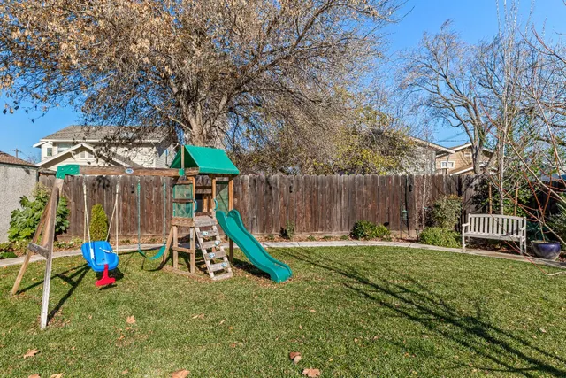 a view of an house with backyard and a tree