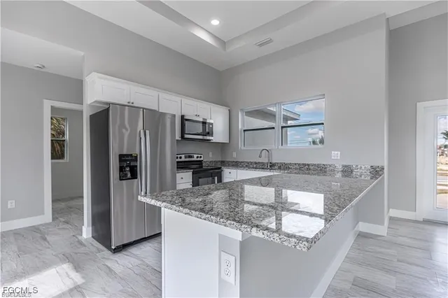a kitchen with stainless steel appliances granite countertop a sink refrigerator and microwave