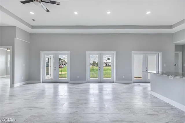 a view of an empty room with window and wooden floor