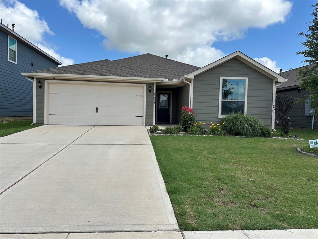 Single story home with driveway, a garage, a front lawn, and a shingled roof