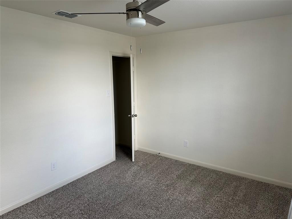 13624 Mineral Road Ponder, TX 76259 - Photo 3 of 26 Unfurnished room with a ceiling fan, dark carpet, and baseboards