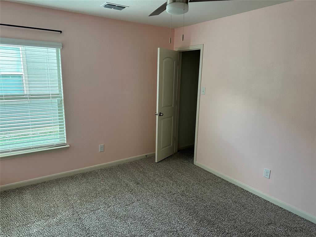 13624 Mineral Road Ponder, TX 76259 - Photo 7 of 26 Empty room featuring a ceiling fan, light colored carpet, plenty of natural light, and baseboards