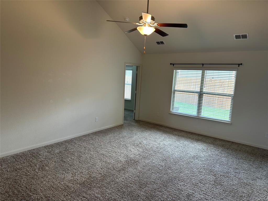 13624 Mineral Road Ponder, TX 76259 - Photo 9 of 26 Carpeted empty room with healthy amount of natural light, a ceiling fan, baseboards, and high vaulted ceiling