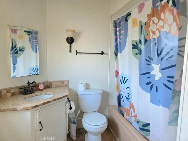 a bathroom with a granite countertop sink a toilet and a mirror
