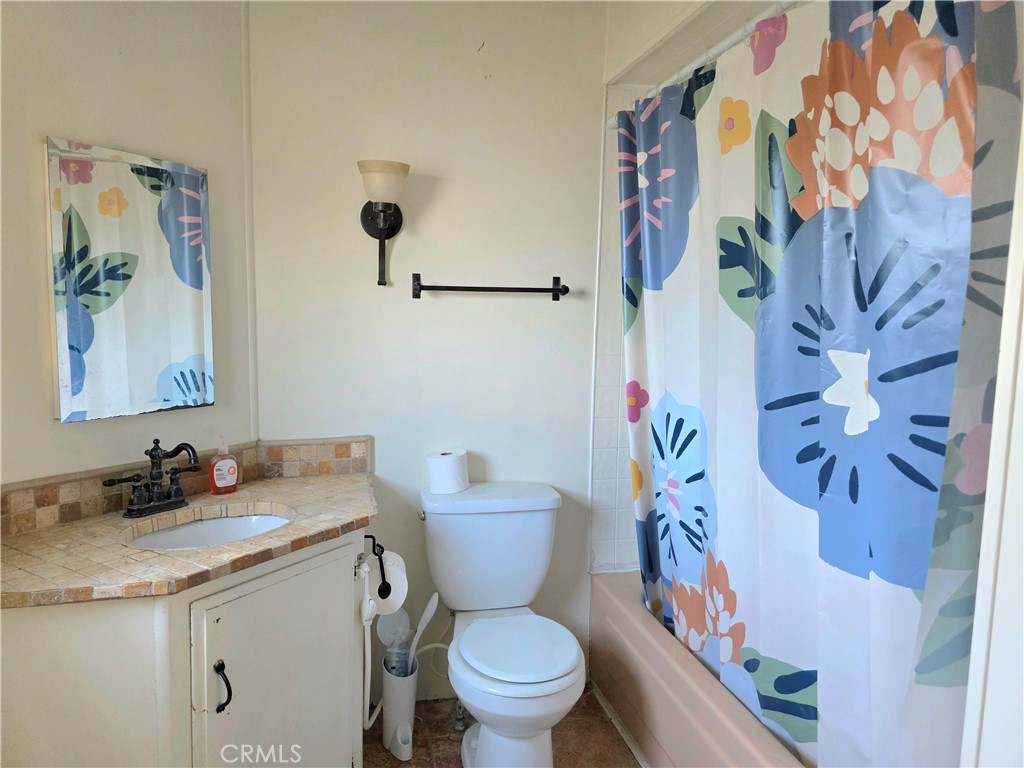 302 Sandpiper, Unit 283 Long Beach, CA 90803 - Photo 16 of 36 a bathroom with a granite countertop sink a toilet and a mirror
