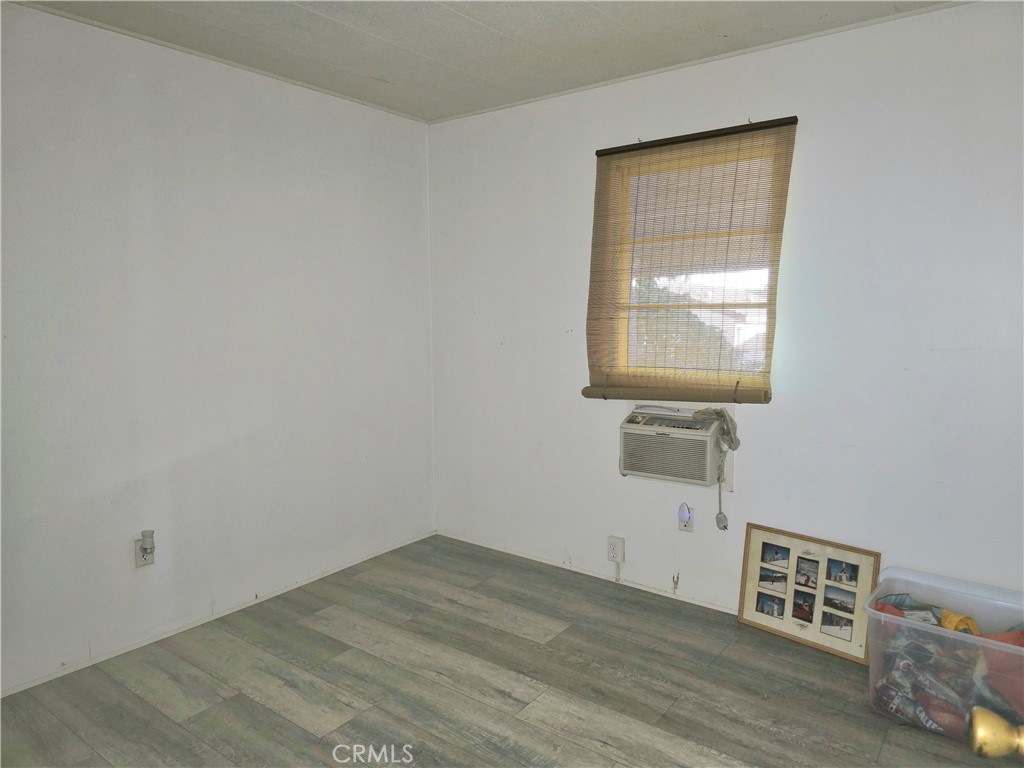 302 Sandpiper, Unit 283 Long Beach, CA 90803 - Photo 20 of 36 a view of an empty room with wooden floor and a window
