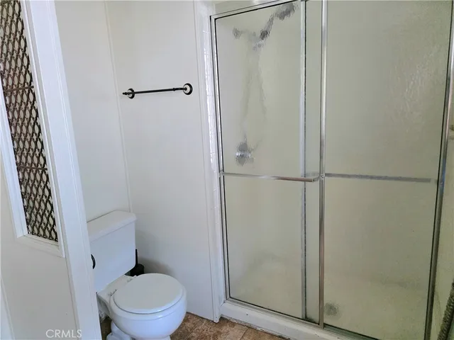 a white toilet sitting next to a shower
