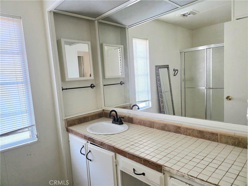 302 Sandpiper, Unit 283 Long Beach, CA 90803 - Photo 22 of 36 a bathroom with a sink and a mirror