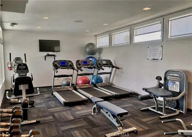 a room with gym equipment and a flat screen tv