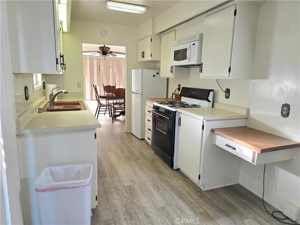 302 Sandpiper, Unit 283 Long Beach, CA 90803 - Photo 10 of 36 a kitchen with a stove a sink and a refrigerator